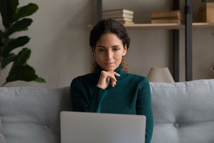 woman thinking in front of laptop