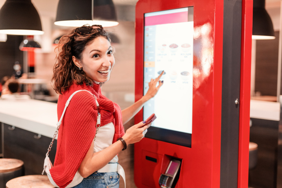 female customer using Kiosk in a restaurant