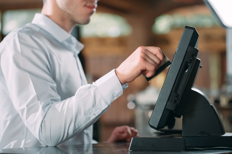 restaurant male staff taking orders from customer and using POS system